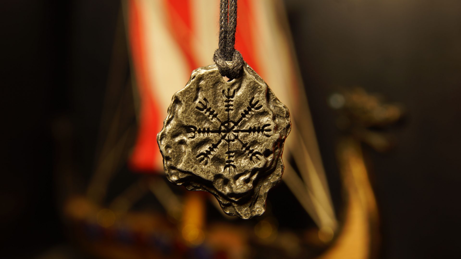 Amulett som hänger framför ett vikingaskepp