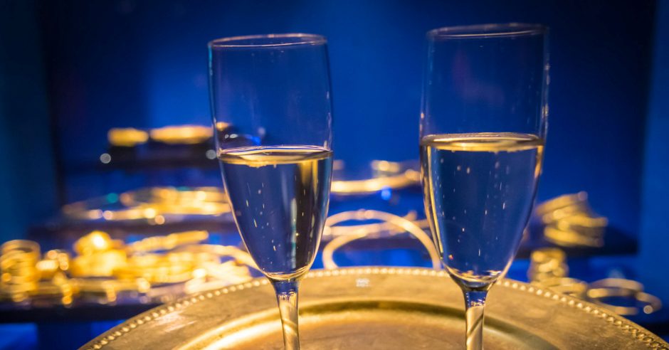 Champagneglas på ett guldfat invid guldföremål