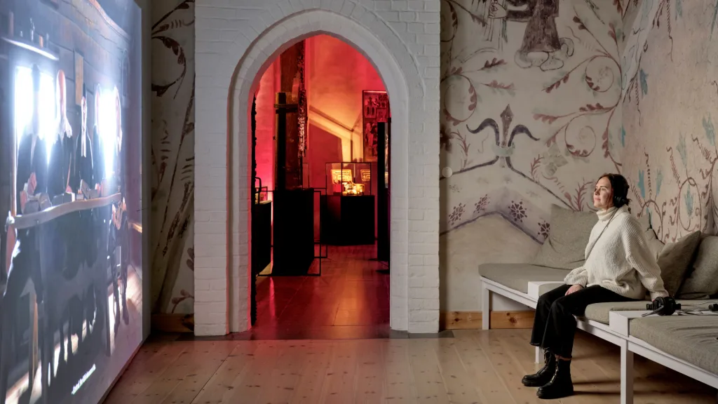 Person sitter och tittar på en film med hörlurar