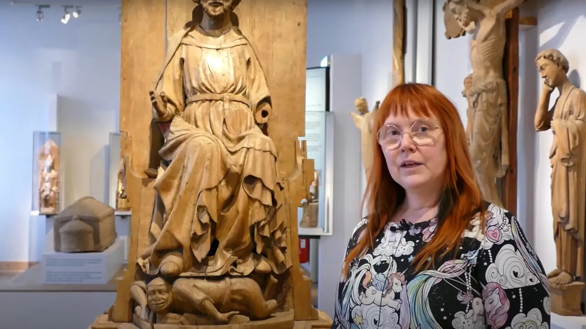 Museianställd framför träskulptur