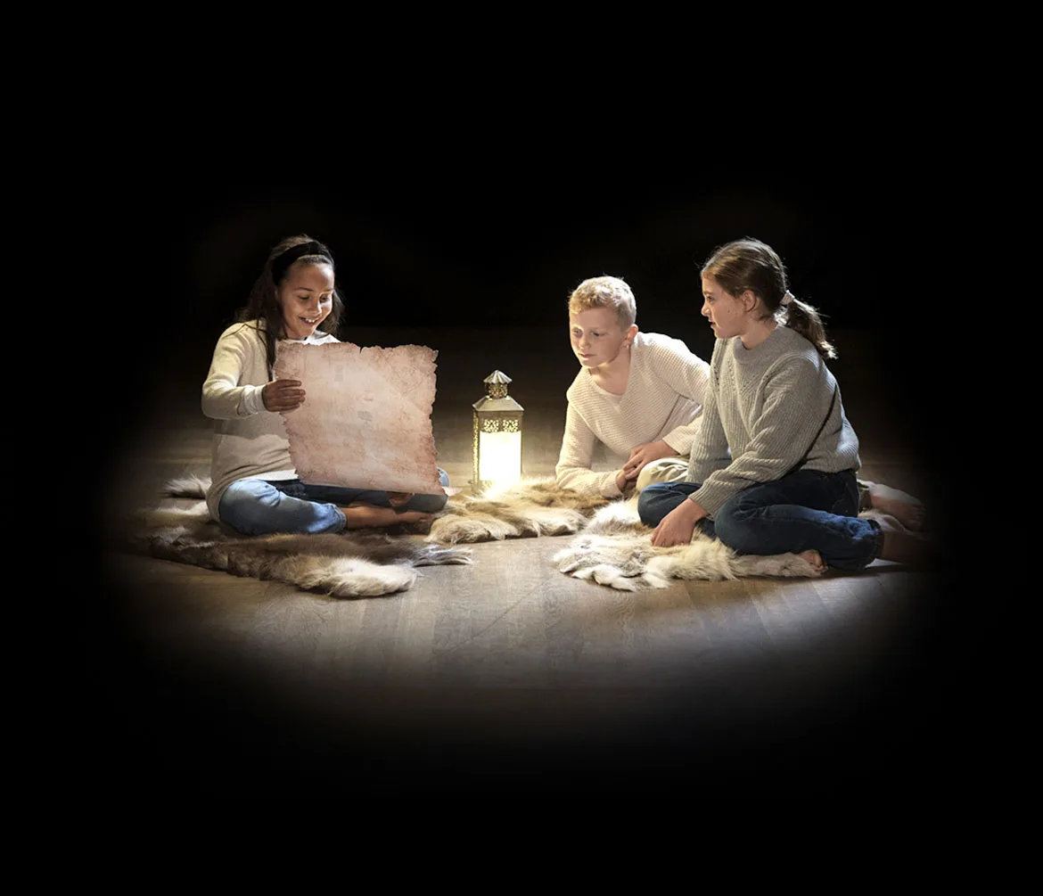 Barn leker tillsammans i en ring med en lykta och karta