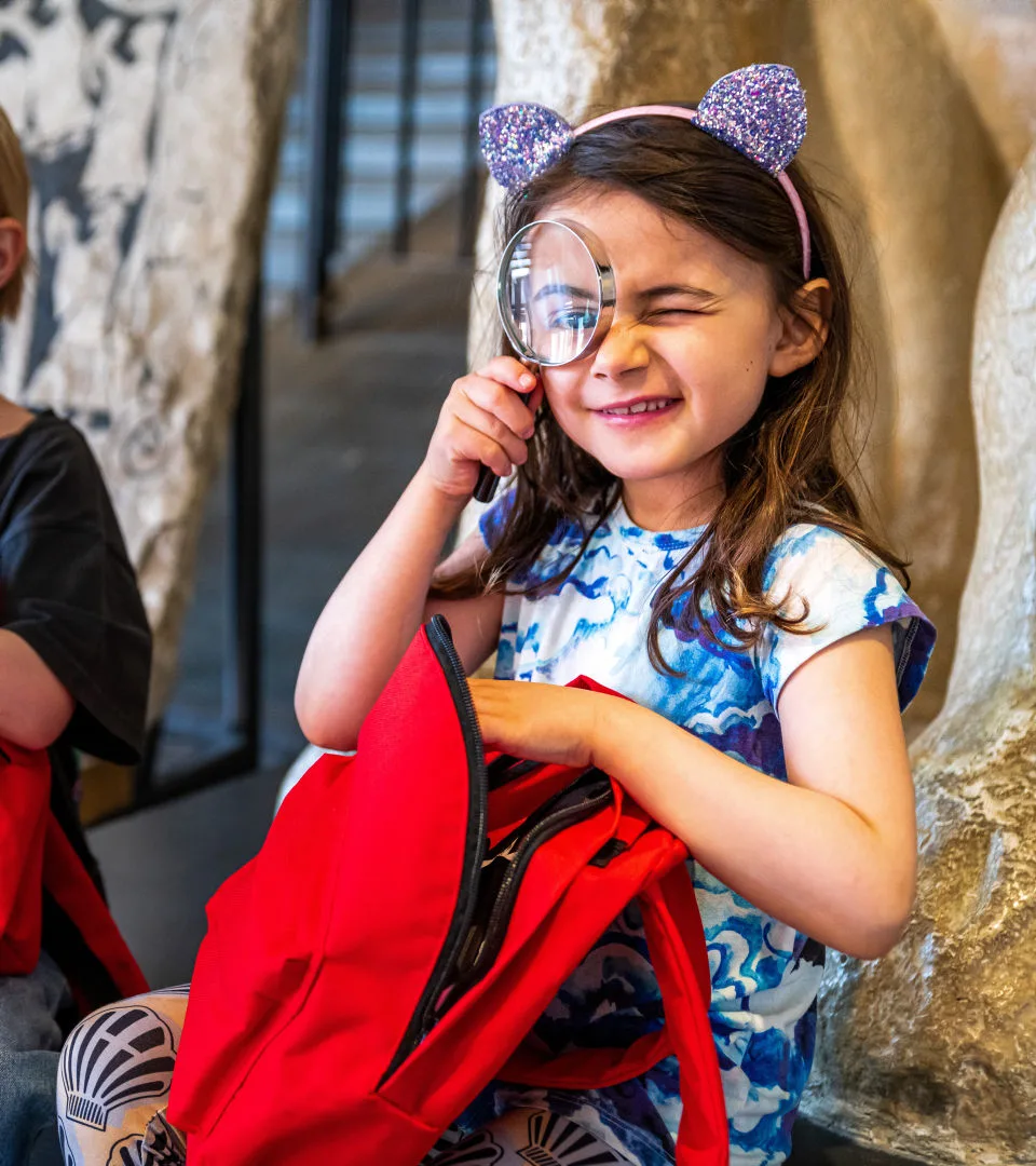 A child sitting with a magnifying glass
