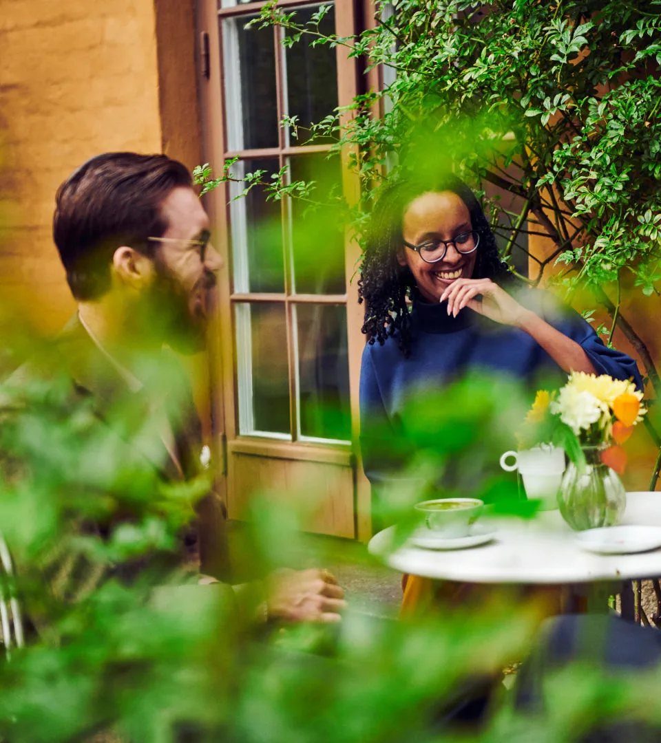 Två personer fikar på restaurangens innegård.