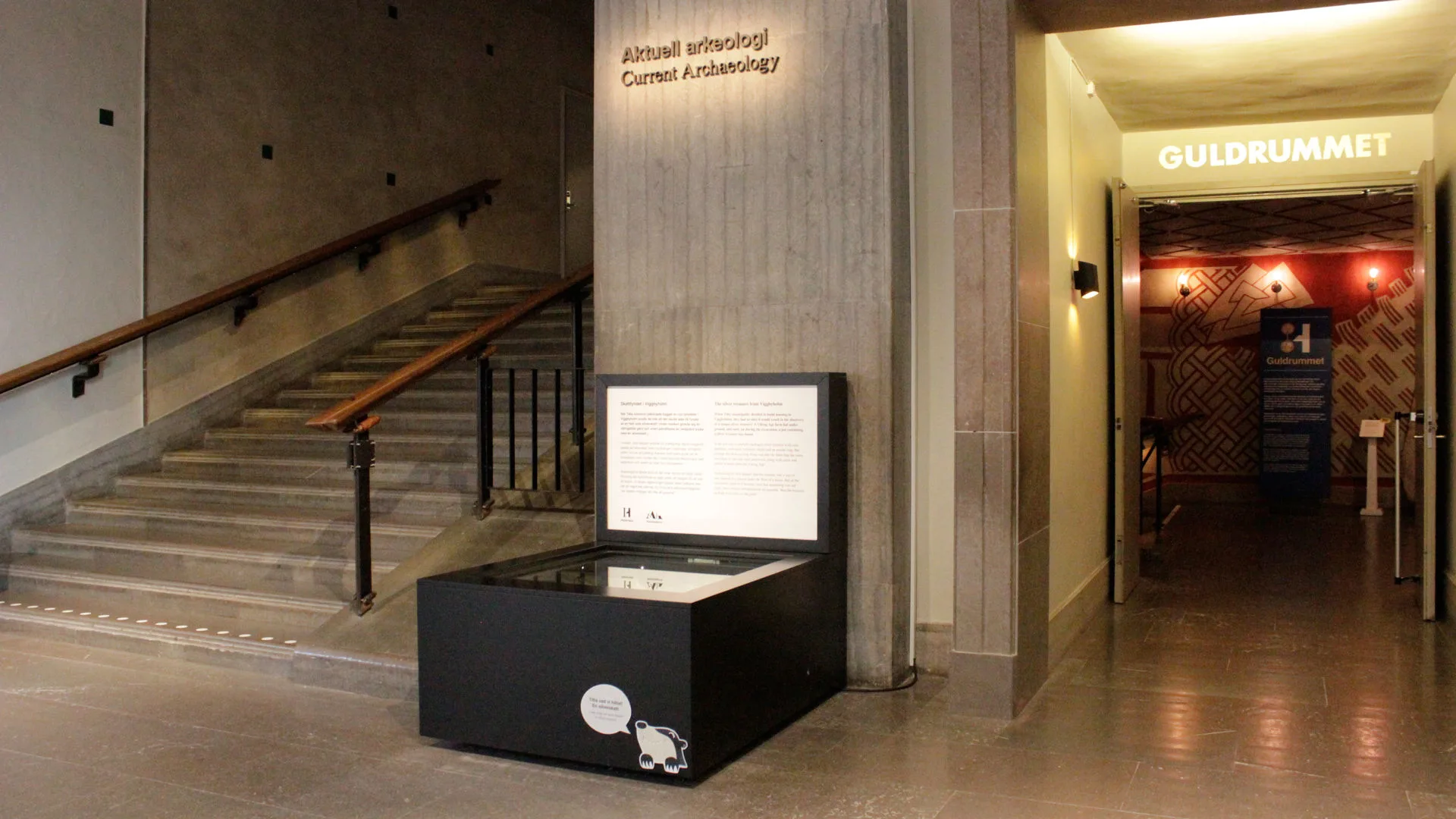 A black display case in the entrance hall. On the wall above, it says Current Archaeology.