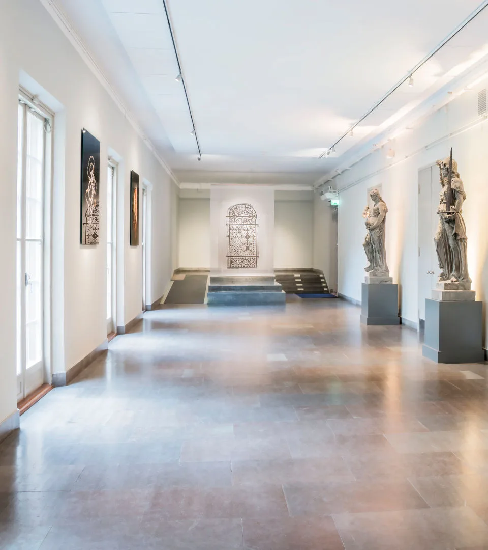 Lejongången med två statyer till vänster och stora fönster till höger.