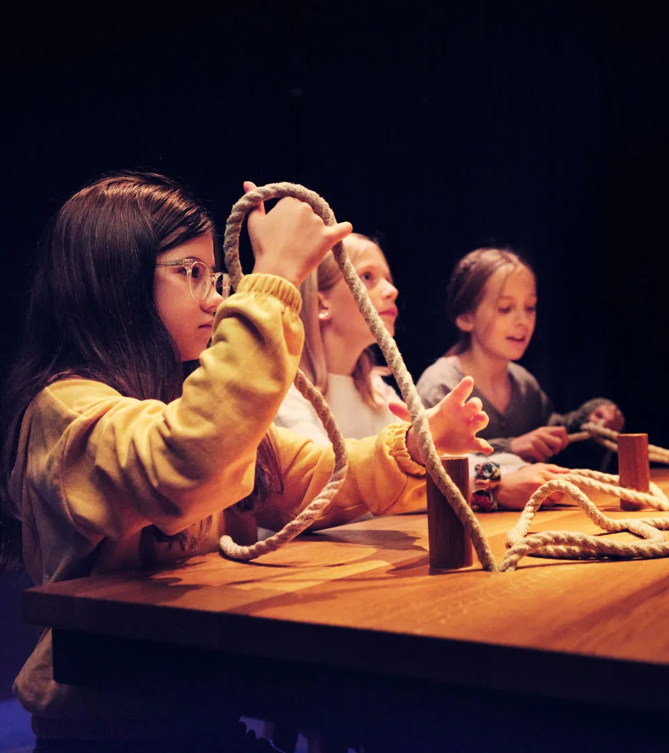 Barn testar att knyta knopar i Vikingarnas värld.