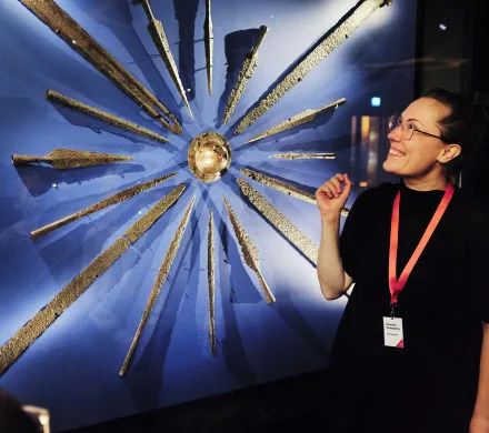 Pedagog visar föremål i utställningen Vikingarnas värld.