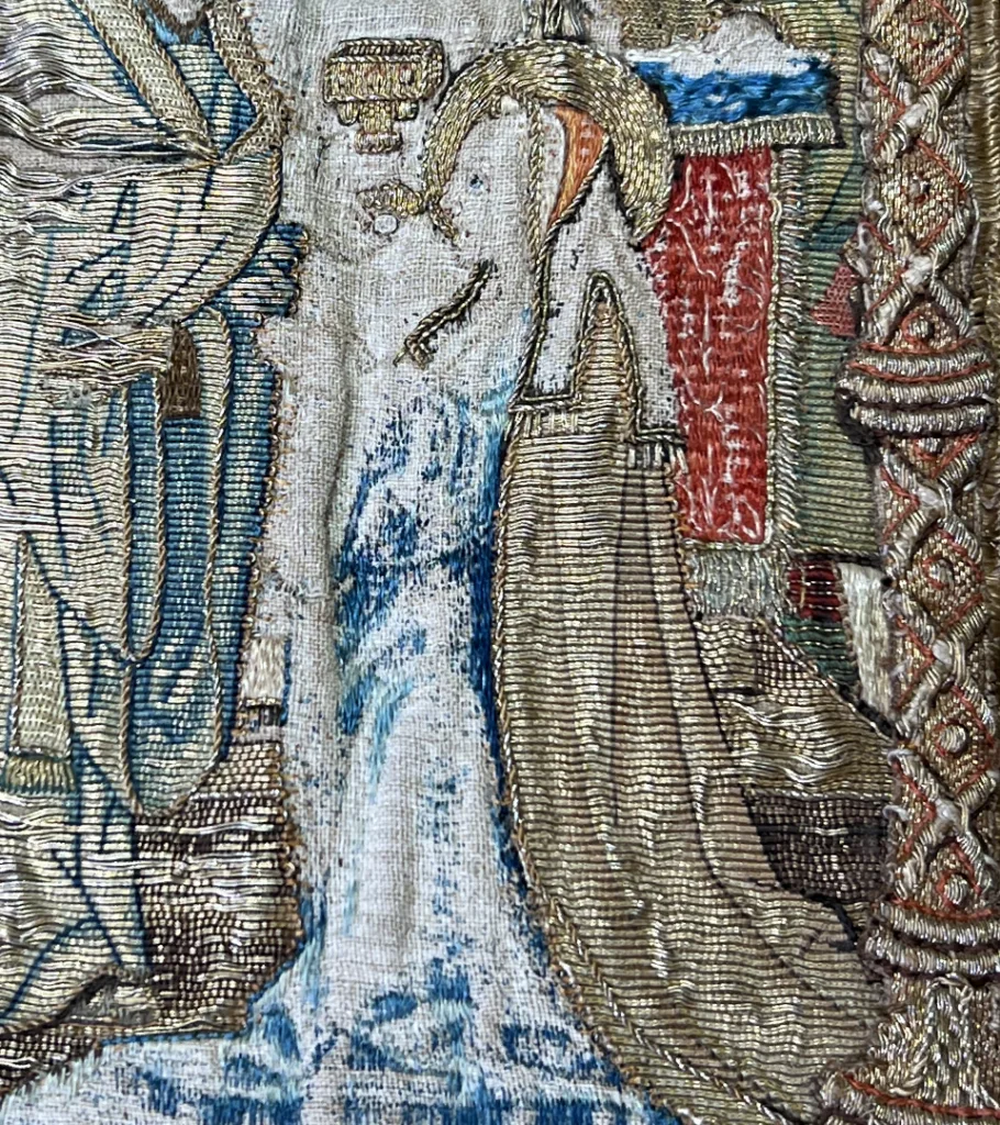 Broderi närbild, kvinna tar emot nattvarden från kyrkoledare