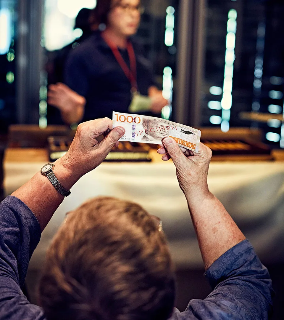 Visitor observing a historical currency bill on display at the museum.