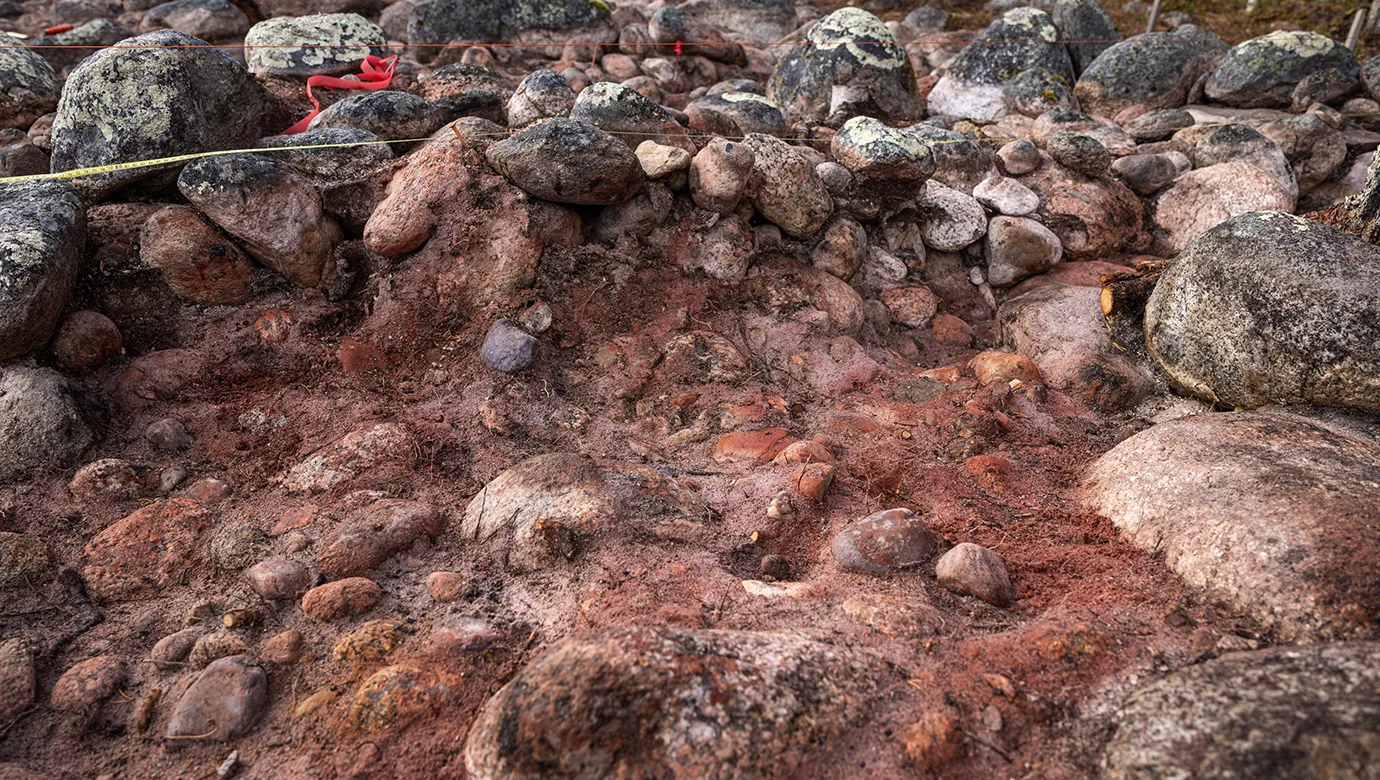 Stenar staplade ovanpå röd jord