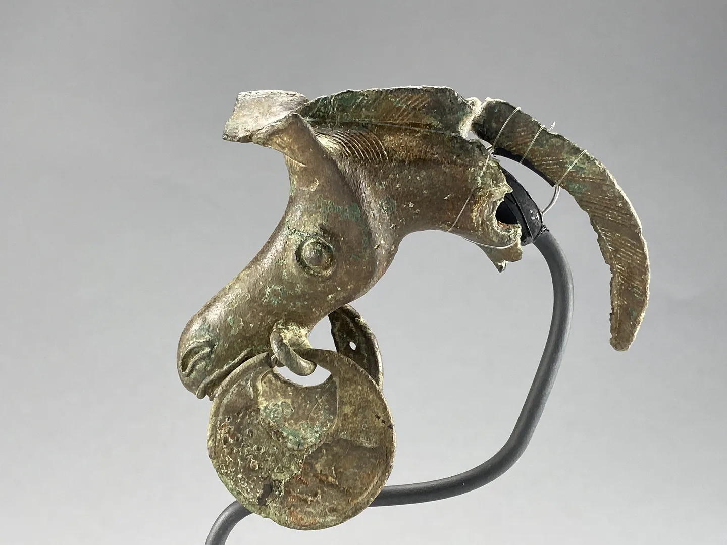 Bronze sculpture of a horse's head with two circular discs.