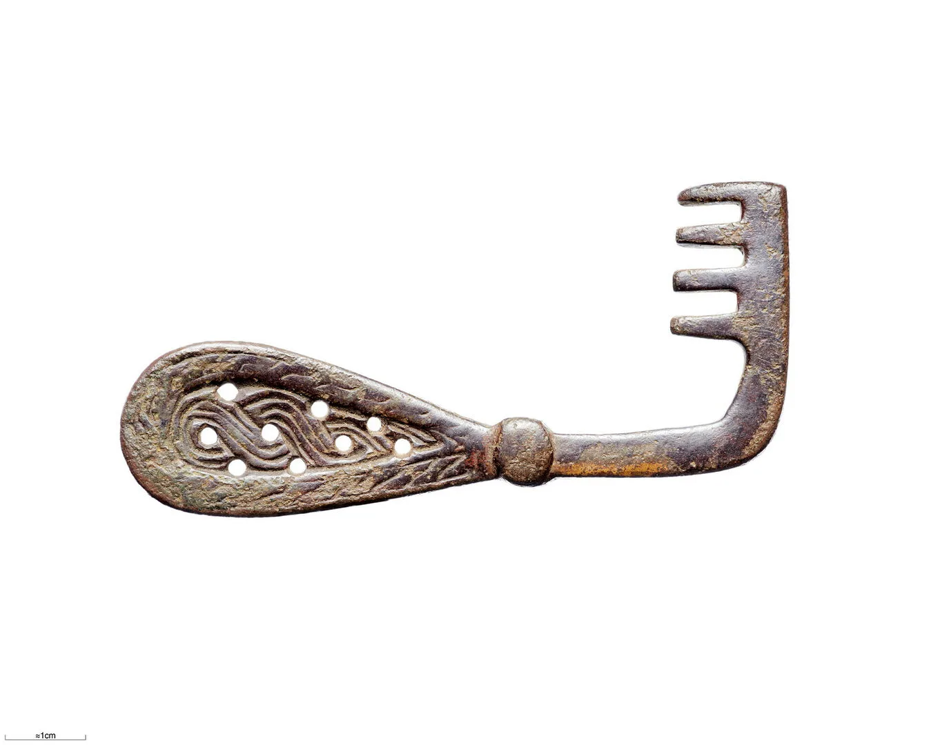 A metal key with a decorated, tear-shaped handle and a bit with four teeth.