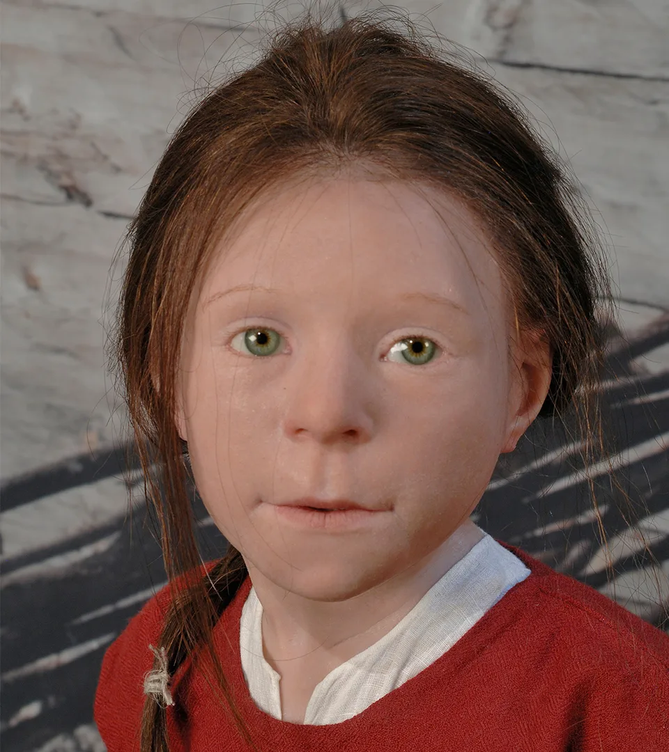 A silicone head of a girl with red hair and green eyes.