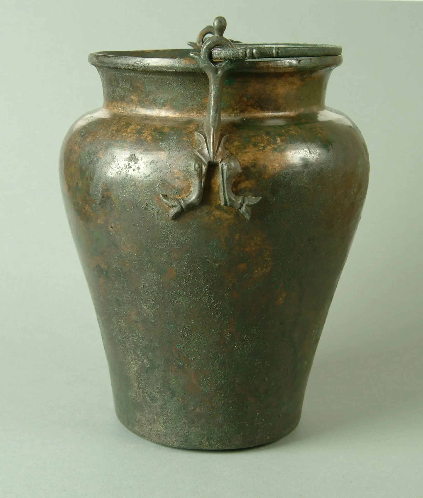 Ett bronskärl med liten bas, vidgande uppåt och bred skuldra och rund mynning med handtag.