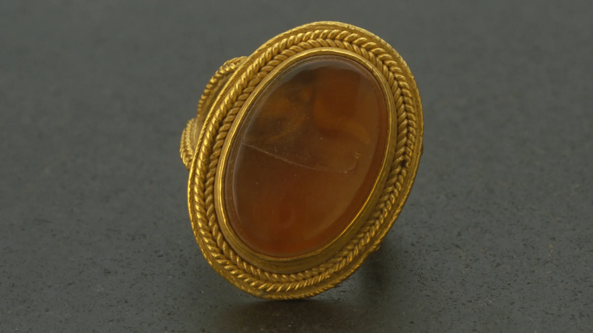 A gold ring with a flat oval-shaped stone