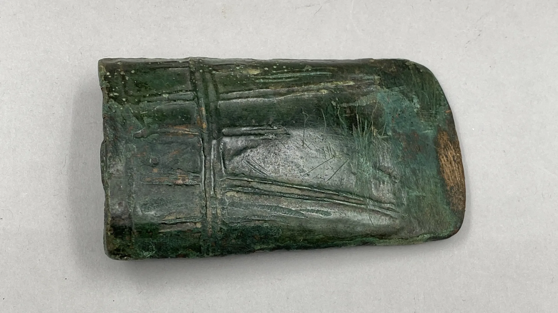 A piece of a bronze axe with decorative ridges