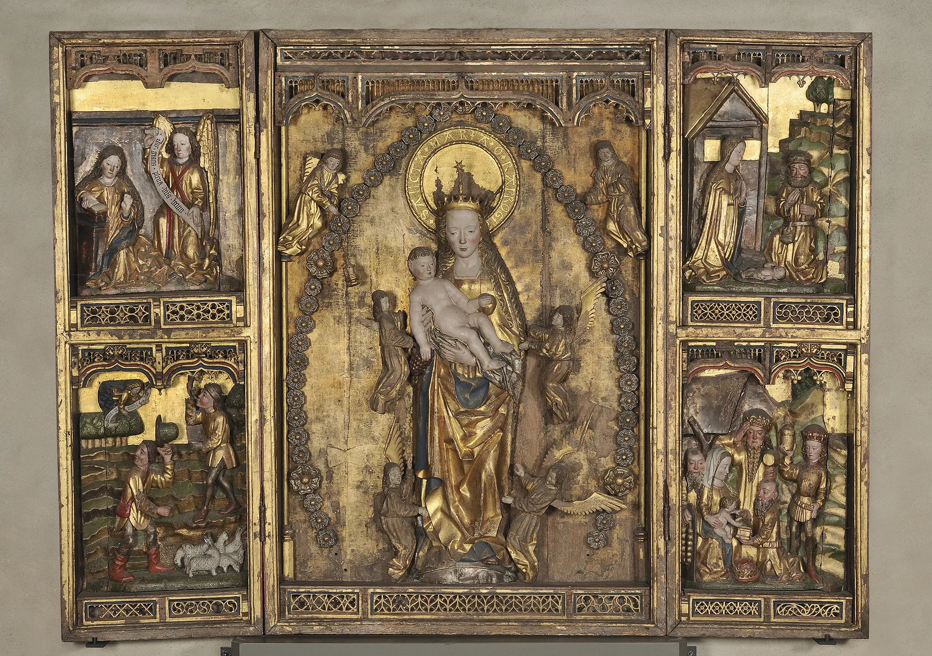 Altarskåp med figuriner avbildandes personer. 