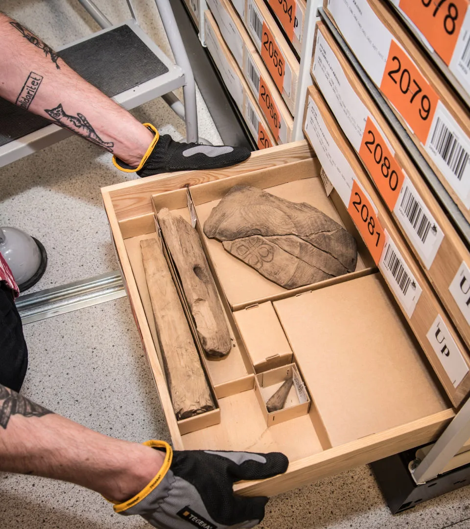 Staff working with materials in the archive, pulling out a drawer.
