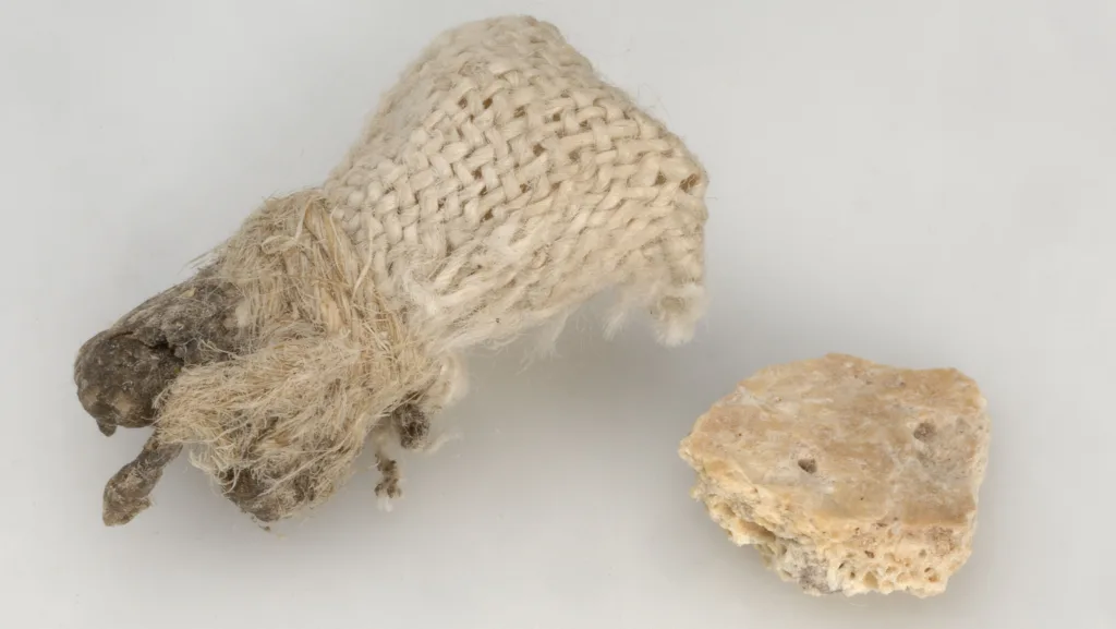 A small cloth bag containing and a bone fragment.