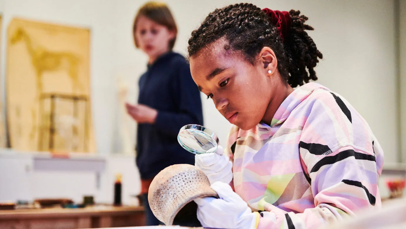 Elev undersöker föremål med ett förstoringsglas.