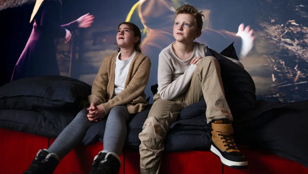 Två barn sitter i utställningen Tillsammans genom tiden.