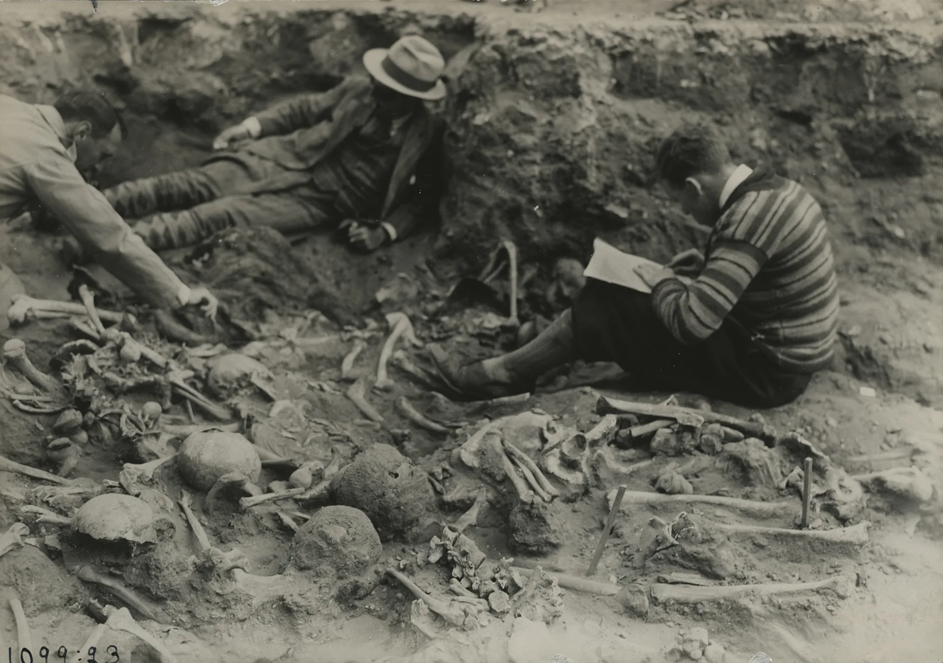 People sitting on the ground surrounded by bone material.
