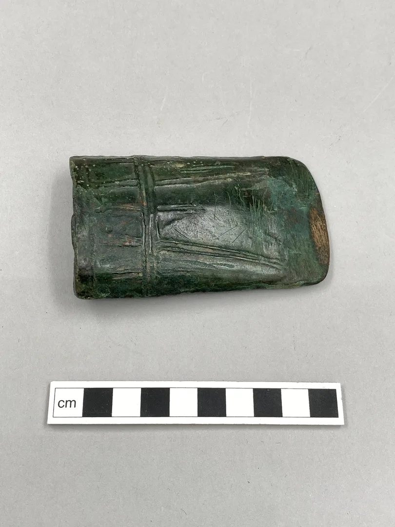 Yxhuvud i brons med ingraverade linjer