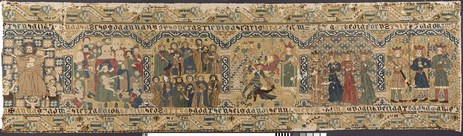 Lång broderad textil med olika bilder och dekorationer.