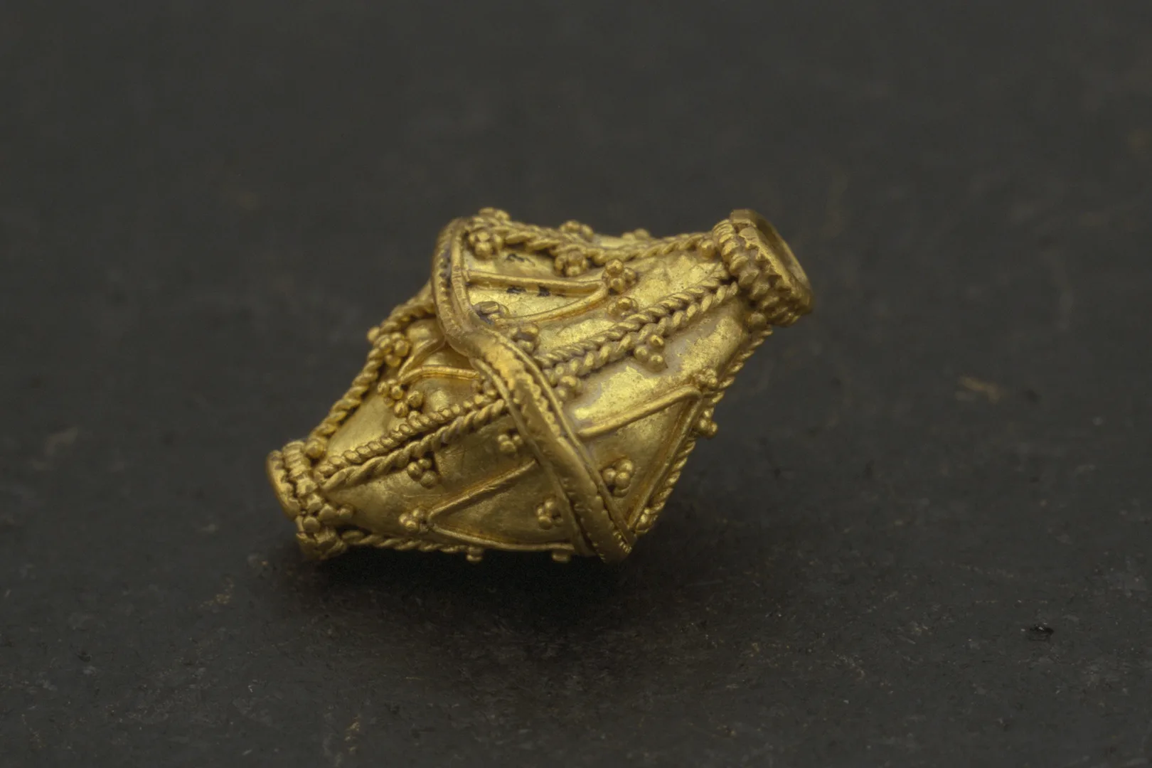 En något tillknycklad guldpärla.