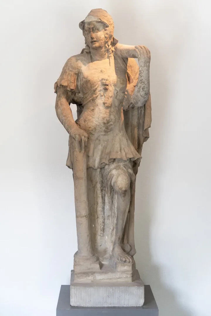 En staty av gulaktig sten, tämligen anfrätt av ålder.