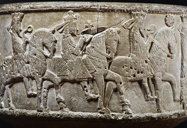 Stenrelief som visar tre män till häst.