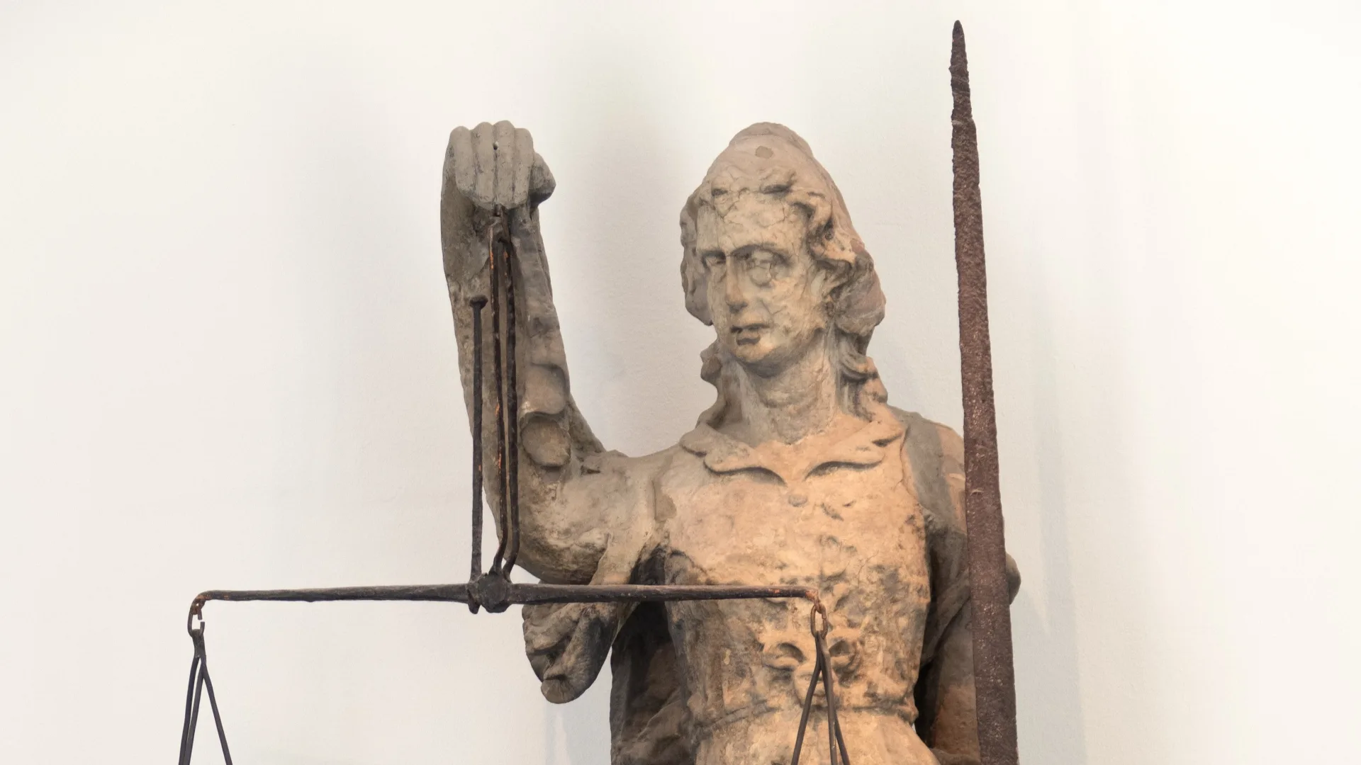 Statue depicting a woman holding a set of scales in one hand and a spear in the other