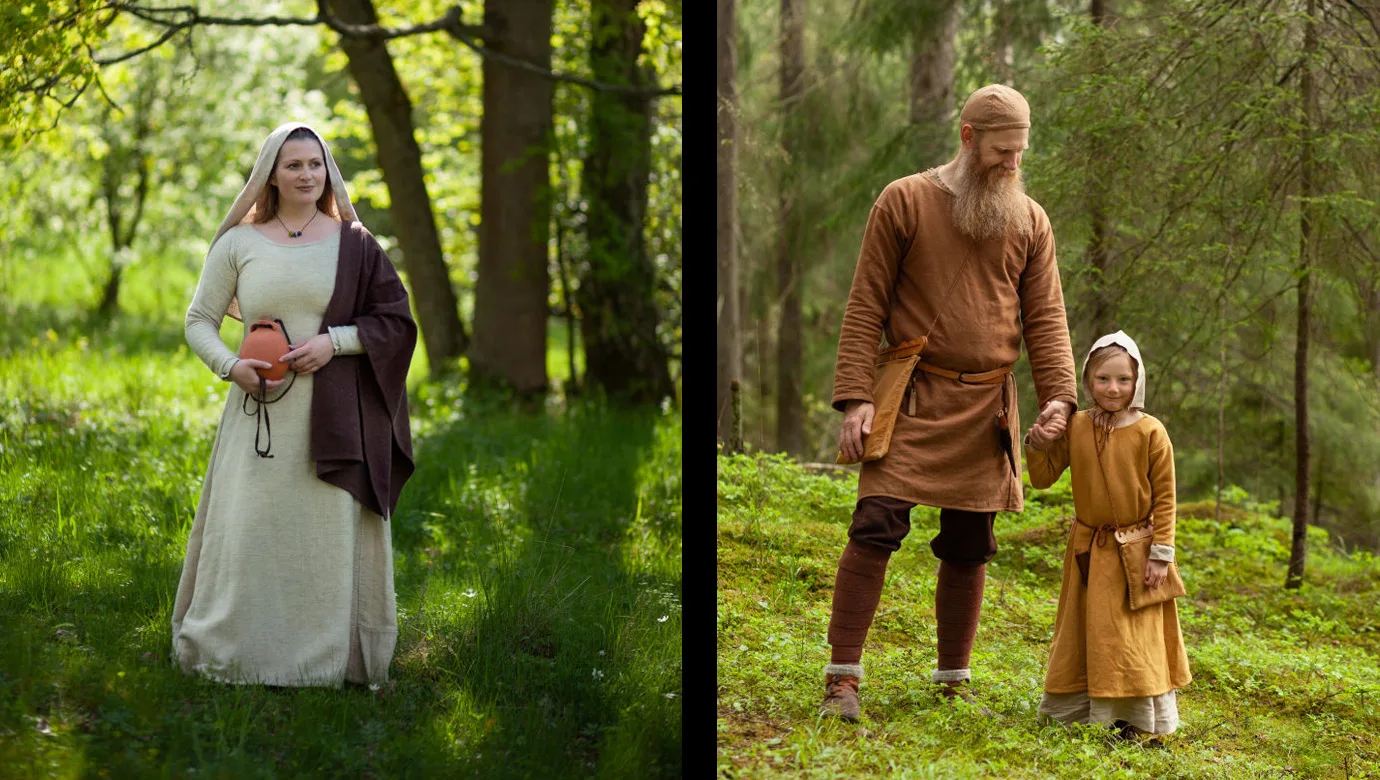 People in reconstructed Viking Age clothes. To the right, an adult holds hands with a child