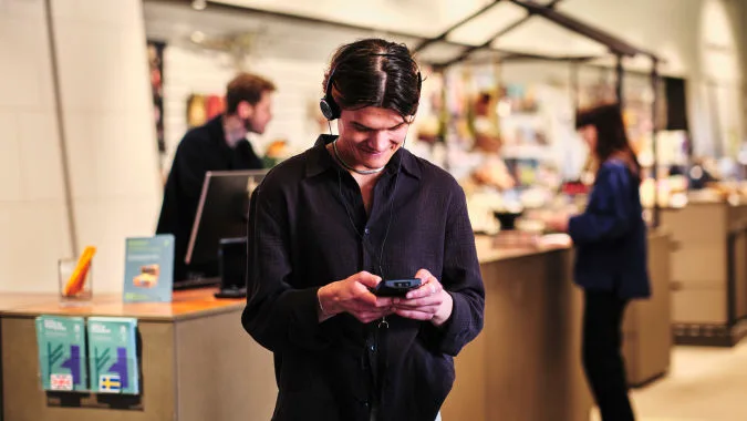 En besökare står med en audioguide.