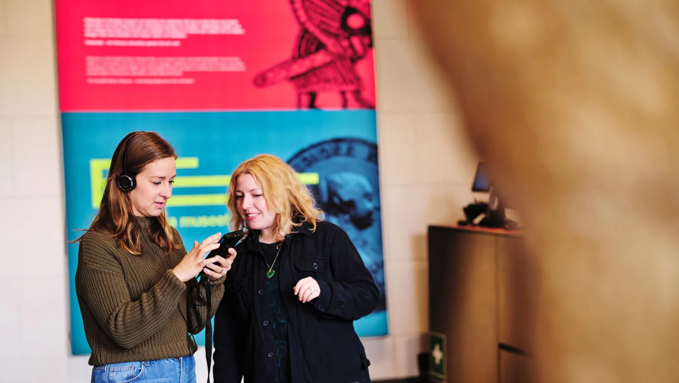 Besökare får hjälp med sin audioguide av en i personalen.