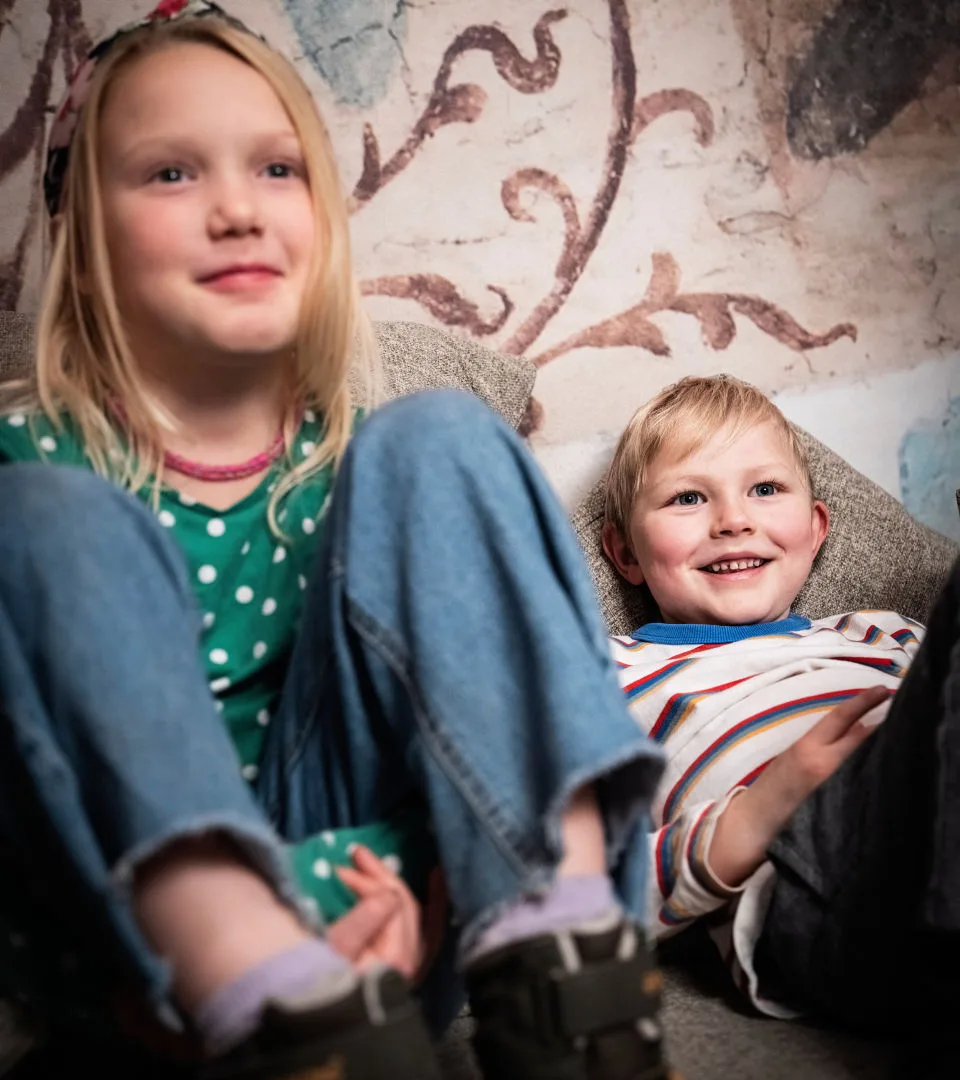 Två barn sitter på golvet.