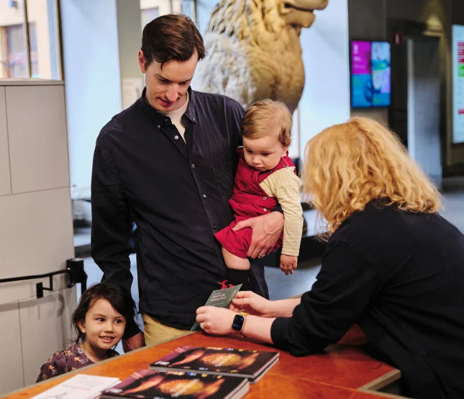 A family buying tickets at the museum entrance.