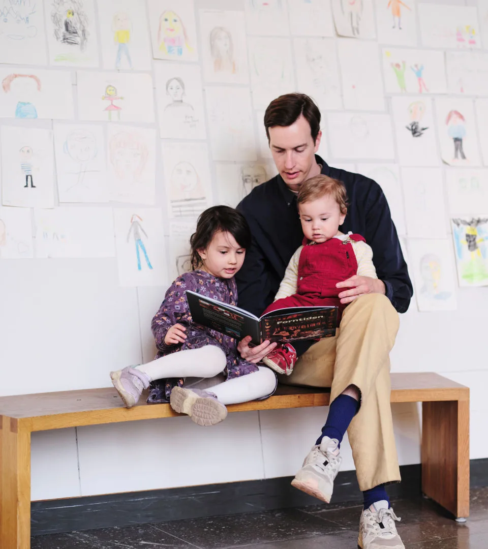Parent and children reading book in the museum entrance