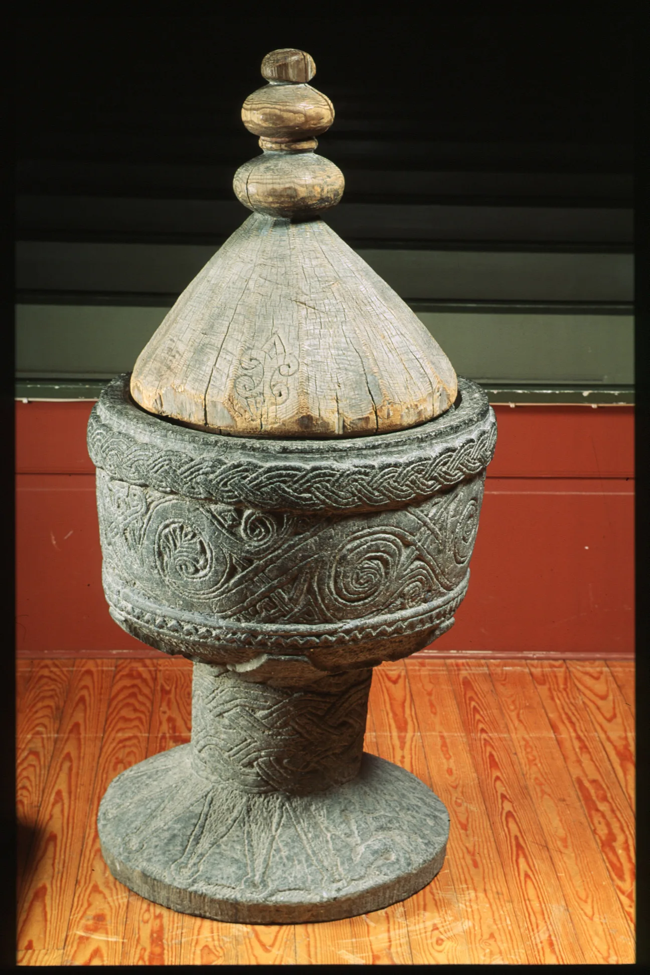 Dopfunt, eller bassäng, i sten med spetsigt lock i trä