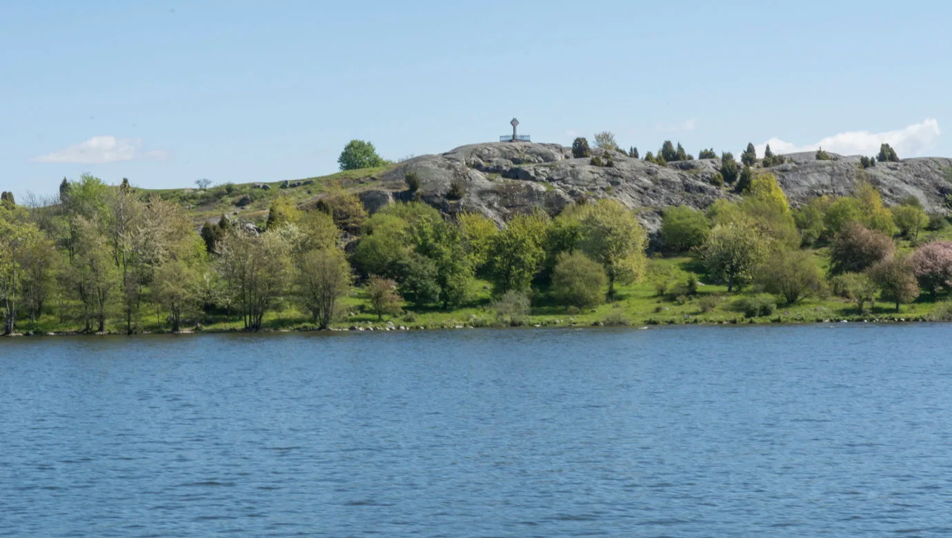 Landscape with rock cliffs and trees, seen from the water.