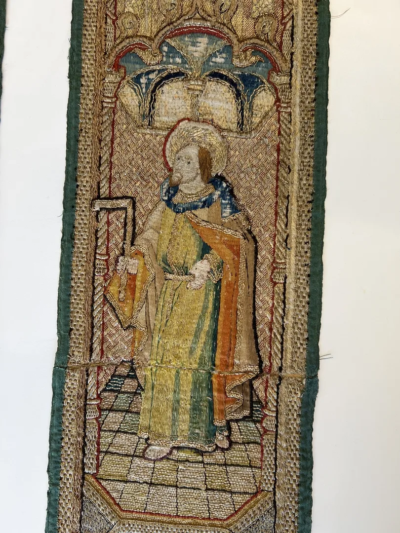 Broderi med helgon som står bland arkitektur