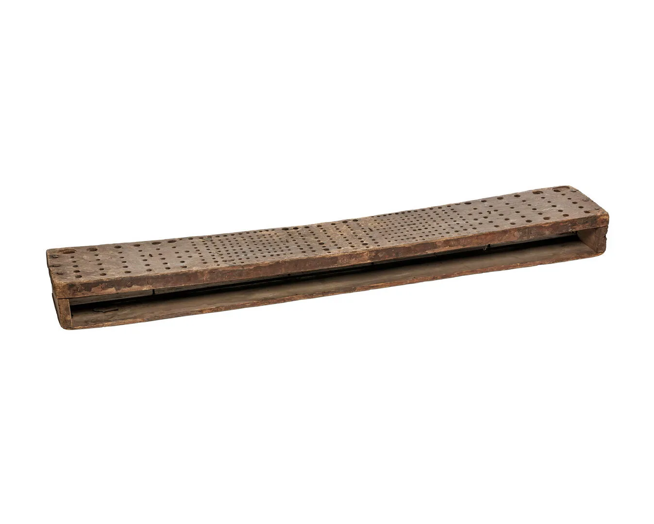 A flat wooden object with a multitude of drilled holes.