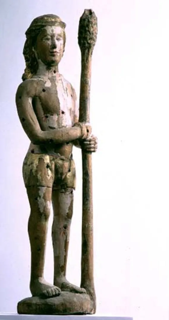 Wooden sculpture of a standing man holding a stick with both hands.