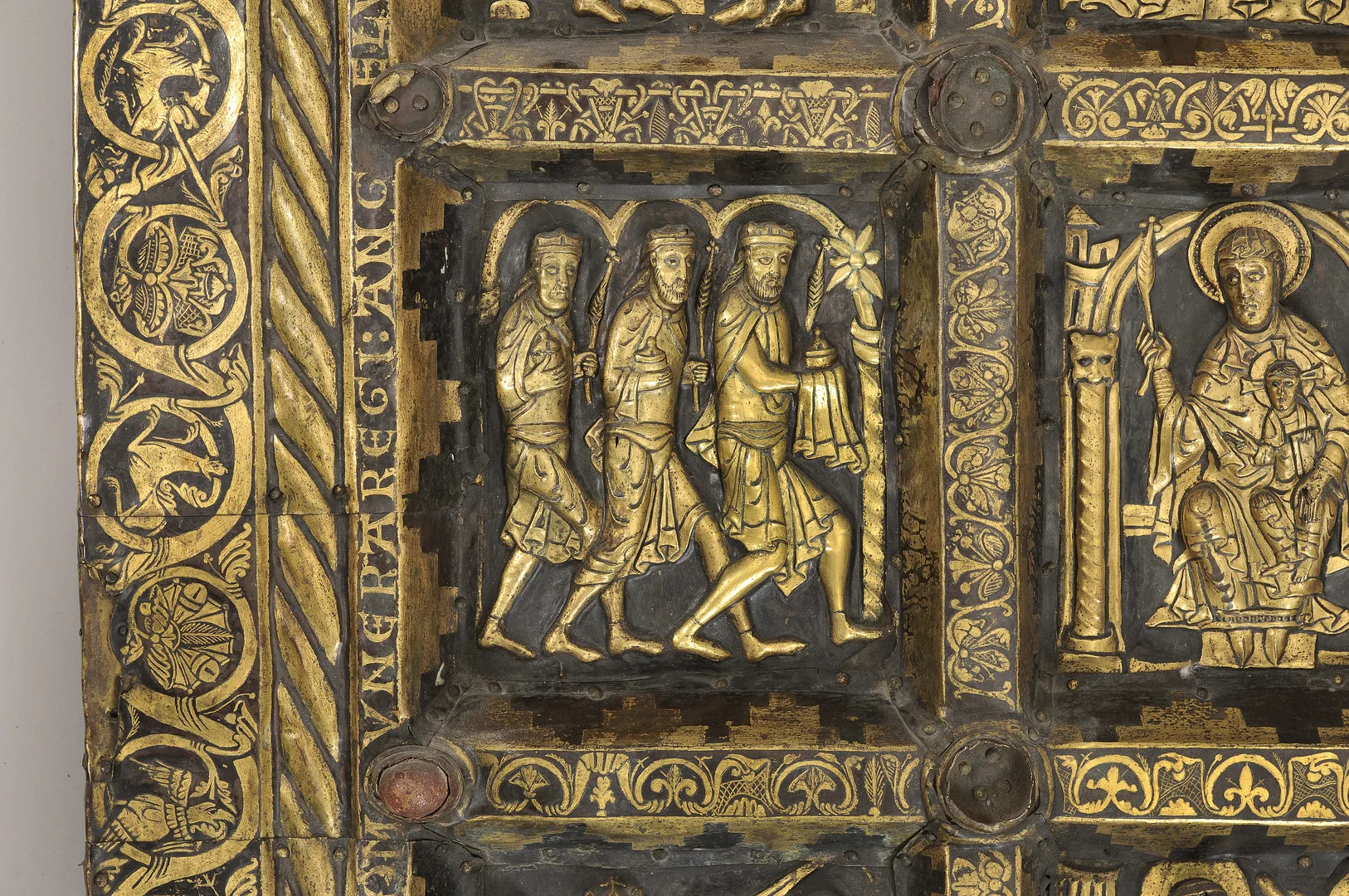 Förgylld inhuggen bild där tre män går och bär på gåvor