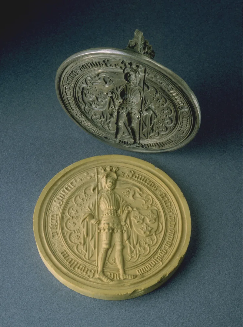 Cirkelformad metallföremål med bild på Sankt Erik