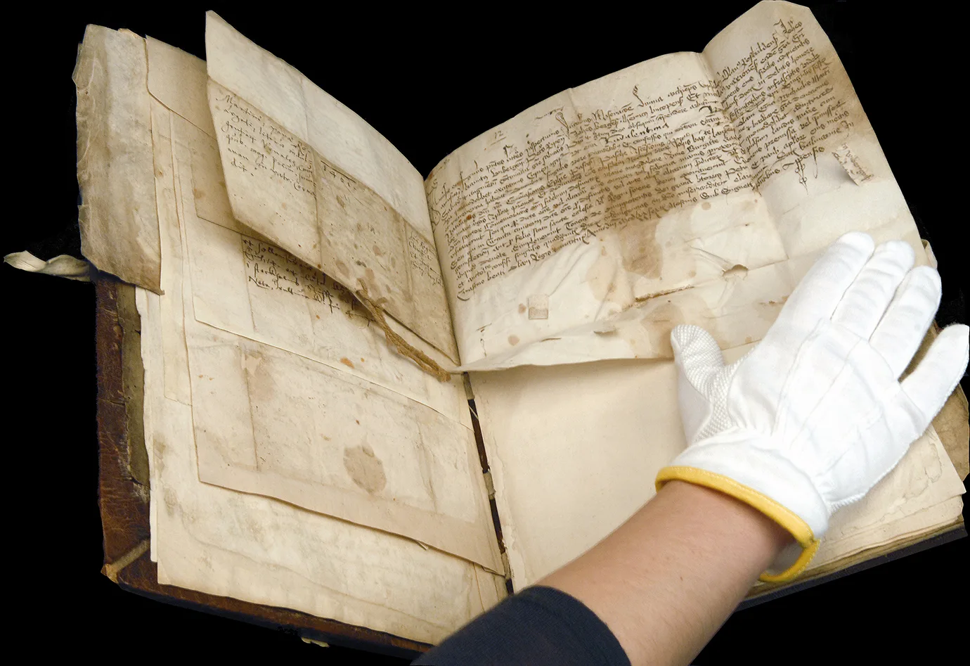 Hand with white gloves opening an old book
