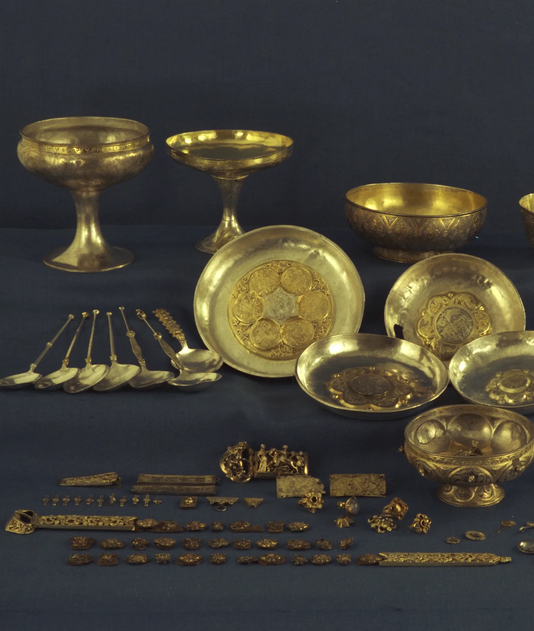 Several cups, spoons, discs, bracelets and other objects of gilt silver.