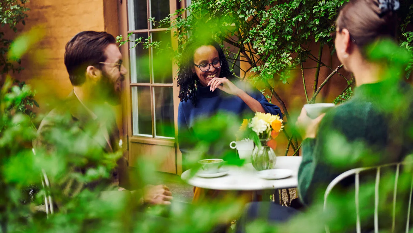 Tre besökare tar en paus för fika på museets innergård.