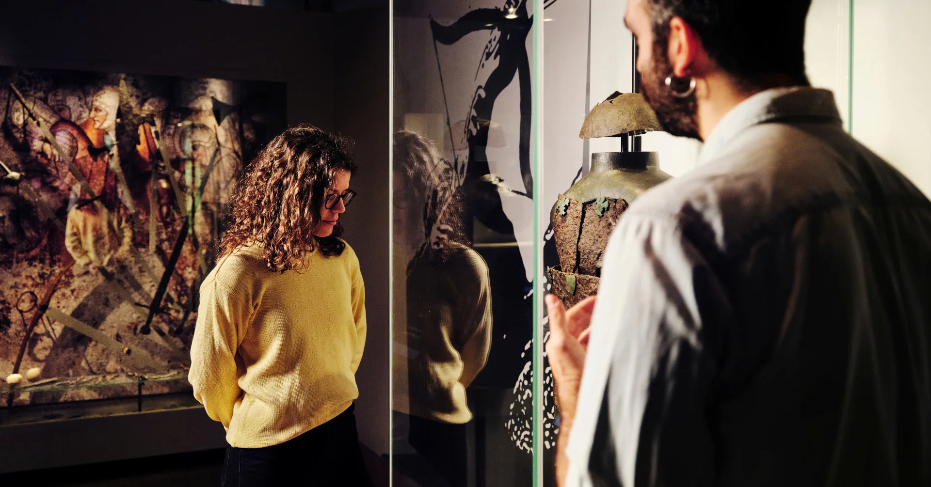 Två besökare tittar på ett föremål i utställningen Massakern vid muren.