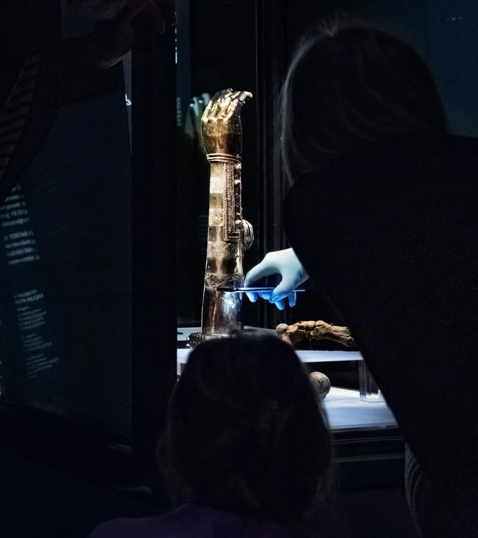 Museum staff working with an object inside a display case.